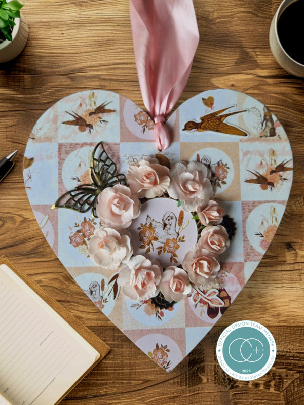 Heart-shaped decorative mat with floral and bird design on a wooden surface