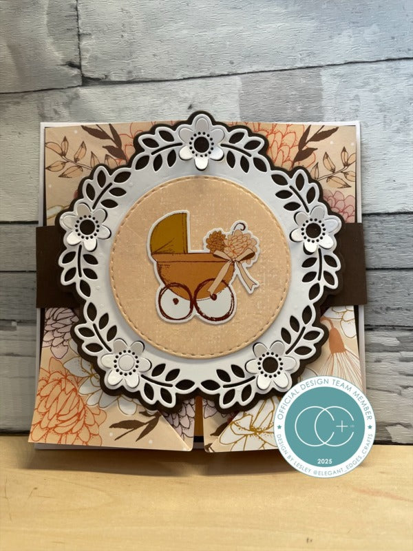 Card with a decorative baby carriage design on a wooden surface