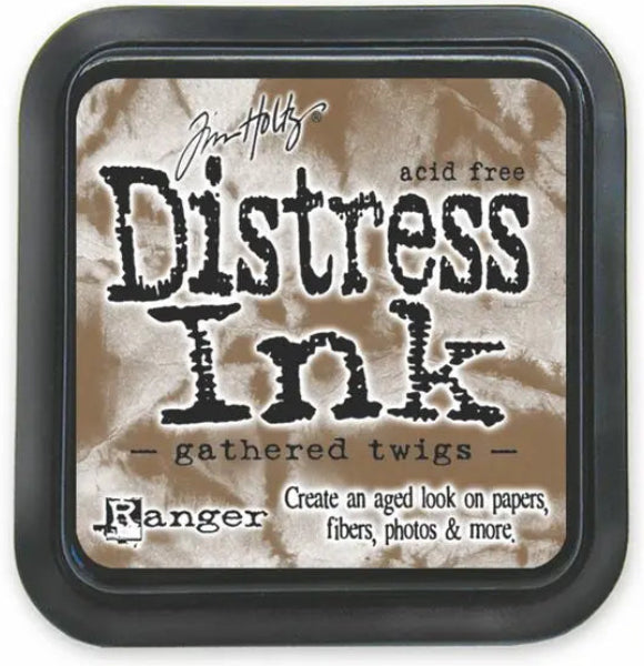 A square Tim Holtz Distress Ink pad in the shade gathered twigs, featuring a black plastic casing and a textured brown paper label inside.