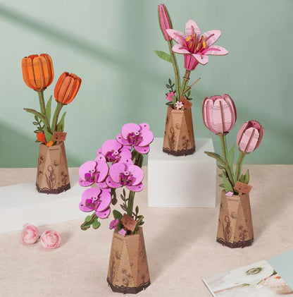 Decorative paper flowers in cardboard vases on a light surface with a green background